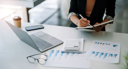 Midsection of businessman working on table