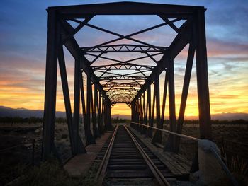 Metal bridge against sky during sunset