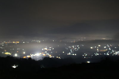 High angle view of illuminated cityscape against sky at night