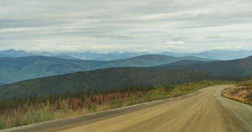 Road leading towards mountains against sky