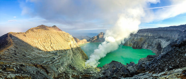 High angle view of hot spring amidst mountains against cloudy sky