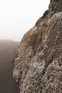 Rock formation on beach against clear sky