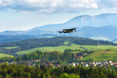 Airplane flying over mountains against sky