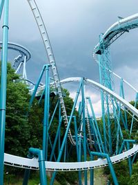 Low angle view of roller coaster ride against sky