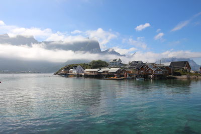 Scenic view of sea by buildings against sky