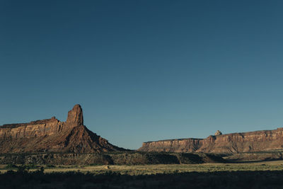 Rock formations against clear blue sky