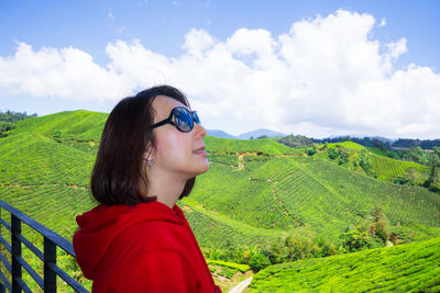 Portrait of young woman in sunglasses against sky