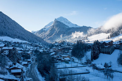 Houses in village against sky during winter