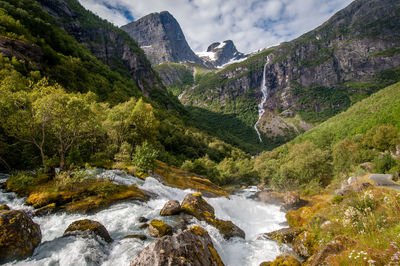 Scenic view of river amidst mountains against sky