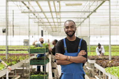 Portrait of young man standing in greenhouse