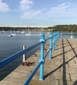 Railing by sea against sky