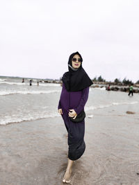 Portrait of young woman standing on beach