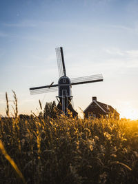 Traditional windmill on field against sky