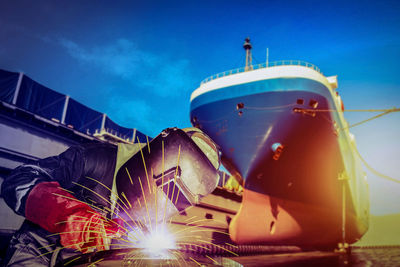 Low angle view of illuminated ship against blue sky