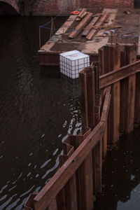 High angle view of wooden pier over lake amidst buildings