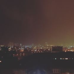 Illuminated cityscape against sky at night