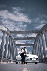 Men standing on bridge against sky