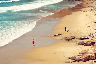 People standing on beach by sea