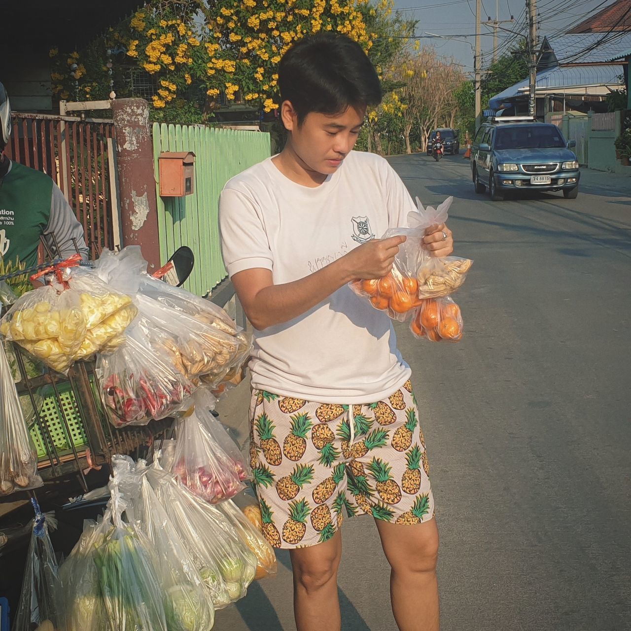 real people, food, food and drink, holding, three quarter length, men, vertebrate, casual clothing, standing, one person, pets, lifestyles, front view, domestic animals, city, leisure activity, market, outdoors