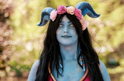 Portrait of woman wearing costume standing against trees