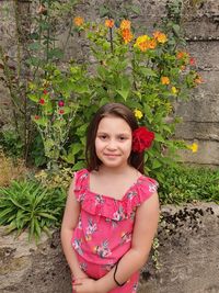 Portrait of smiling girl standing against plants