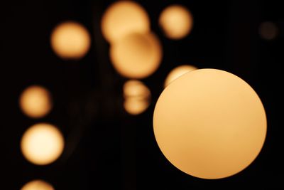 Close-up of illuminated light bulb against sky