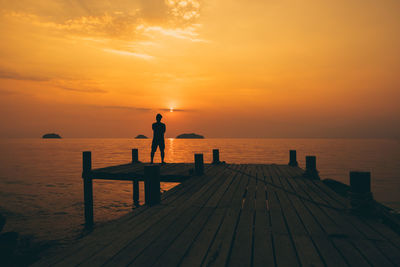 Scenic view of pier on sea against sunset sky