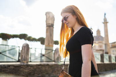 Glad young woman walking on sunny day