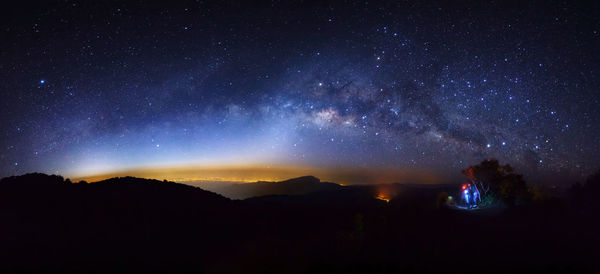 Silhouette mountain against star field at night