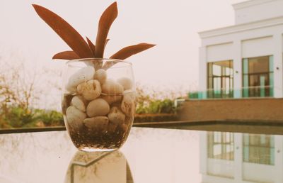 Close-up of sculpture by window on table against building