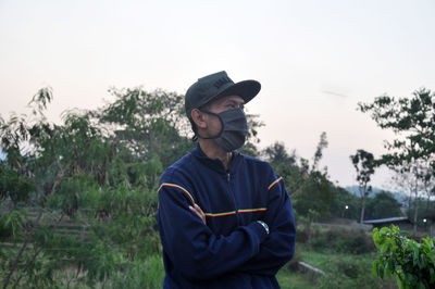 Young man standing on field against sky