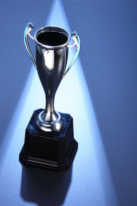 Close-up of trophy on blue table