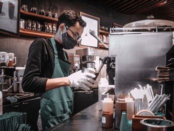 Mid adult man standing in front of cafe