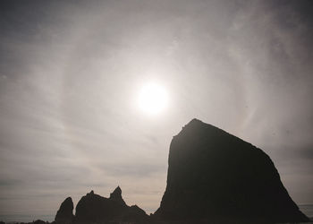 Low angle view of silhouette cliff against sky during sunset