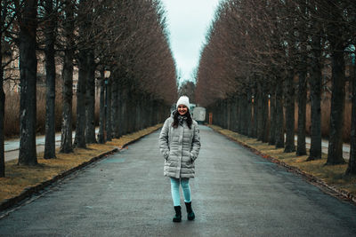 Rear view of man walking on road amidst trees