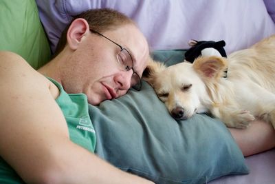 Midsection of man sleeping on bed at home