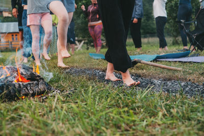 Low section of people walking on grass