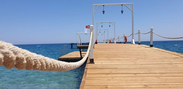 Pier over sea against clear sky