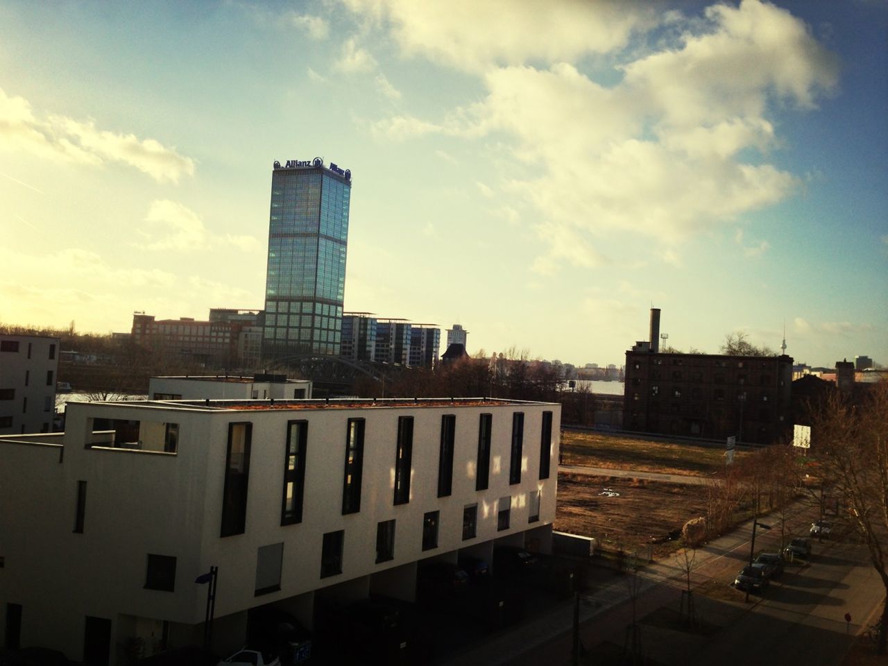 building exterior, architecture, built structure, city, sky, skyscraper, cityscape, cloud - sky, office building, modern, transportation, building, tower, tall - high, city life, car, urban skyline, road, street, cloud