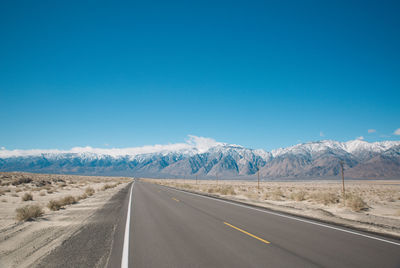 Empty road along countryside landscape