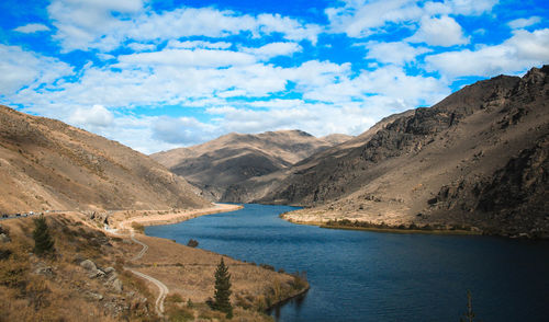 Scenic view of river amidst mountains against sky