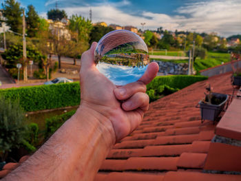 Cropped image of person holding umbrella against built structure