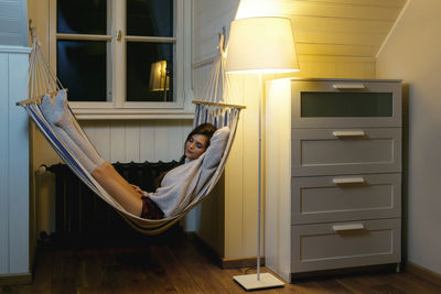 Rear view of woman sitting on sofa at home