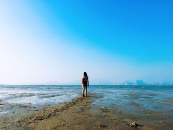 People on beach against clear sky