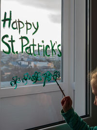 Hand holding glass window with text