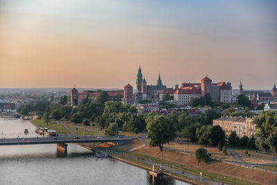 Buildings in city against sky during sunset