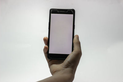 Midsection of person holding smart phone against white background