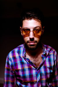 Portrait of young man against black background