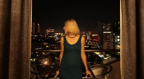 Portrait of woman on balcony at night