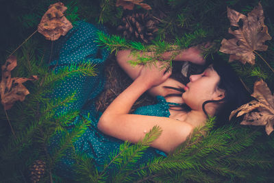 High angle view of woman sleeping amidst plant